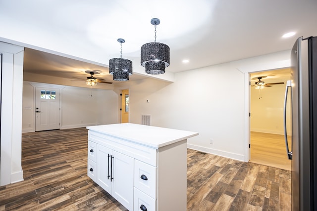 kitchen with pendant lighting, stainless steel fridge, dark hardwood / wood-style flooring, and white cabinetry