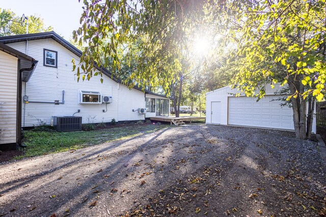 view of home's exterior featuring central AC unit, a garage, and an outdoor structure