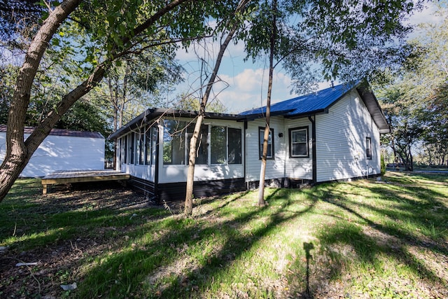 view of front of home with a front lawn and a sunroom