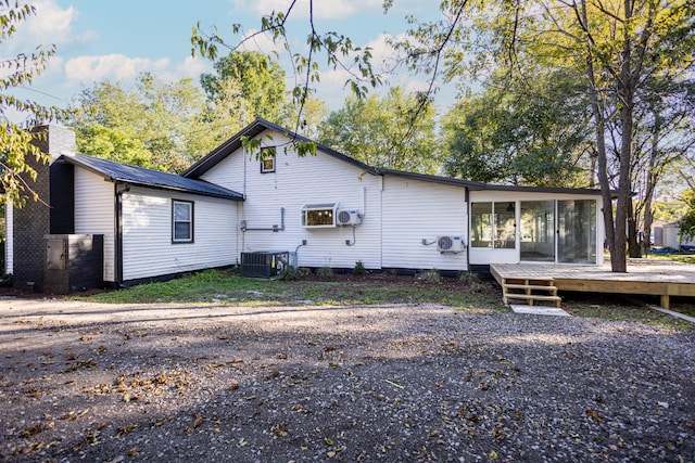 back of house with central air condition unit, a deck, and a sunroom