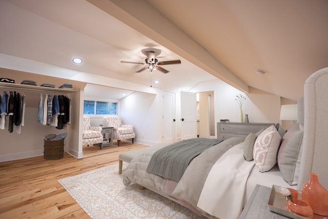 bedroom featuring a closet, ceiling fan, light hardwood / wood-style flooring, and lofted ceiling