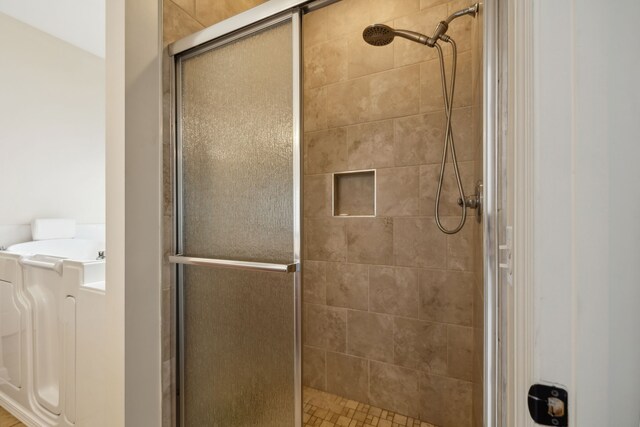 bathroom featuring a shower with door