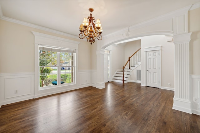 unfurnished room featuring ornate columns, an inviting chandelier, dark hardwood / wood-style flooring, and ornamental molding