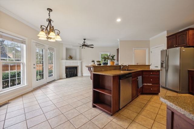 kitchen with ceiling fan with notable chandelier, light tile patterned flooring, crown molding, pendant lighting, and appliances with stainless steel finishes