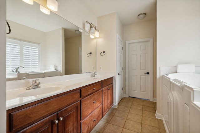 bathroom with a washtub, vanity, and tile patterned floors