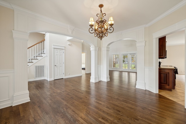 interior space featuring wood-type flooring, ornate columns, crown molding, and a chandelier