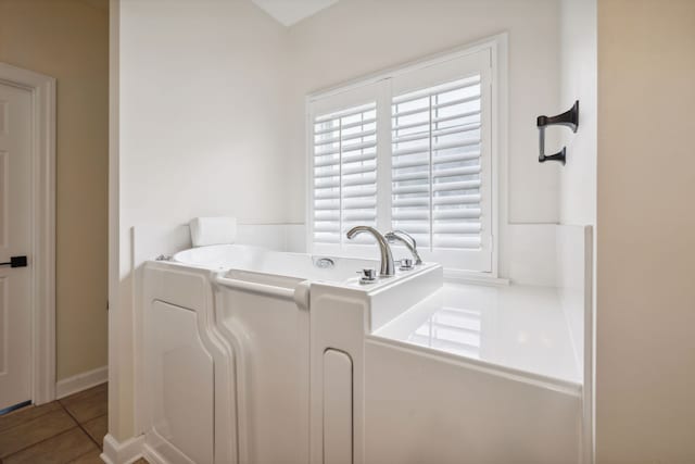 clothes washing area with dark tile patterned floors