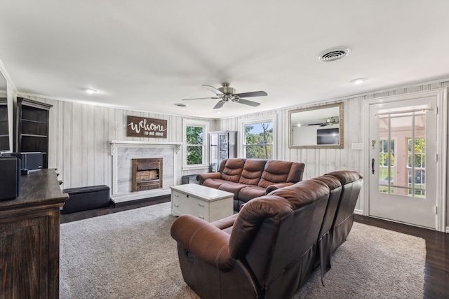 living room with ceiling fan, a fireplace, dark hardwood / wood-style floors, and a healthy amount of sunlight