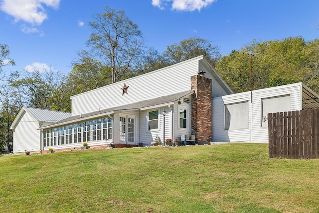 back of property featuring a sunroom and a yard