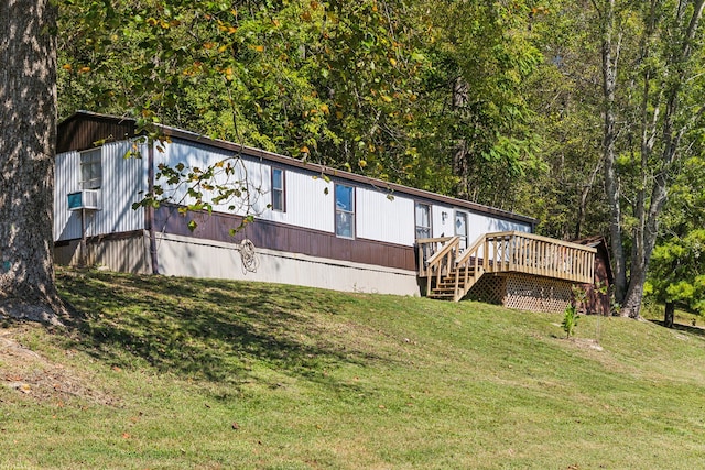 rear view of house featuring cooling unit, a wooden deck, and a lawn