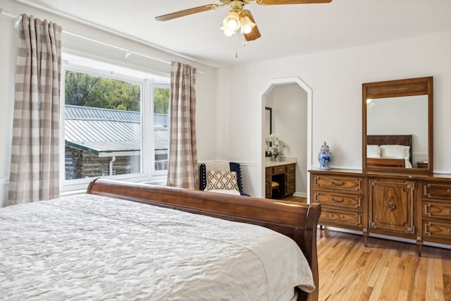 bedroom with ceiling fan, connected bathroom, and light hardwood / wood-style flooring