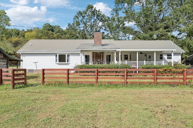 back of house featuring a yard and covered porch