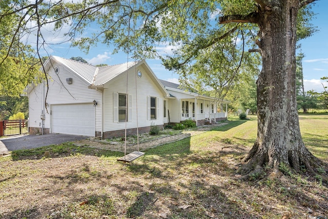 view of front of home featuring a garage, a front lawn, and covered porch