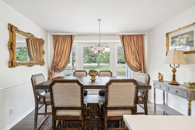 dining area featuring dark hardwood / wood-style floors and a chandelier