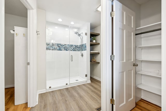 bathroom featuring hardwood / wood-style floors and an enclosed shower