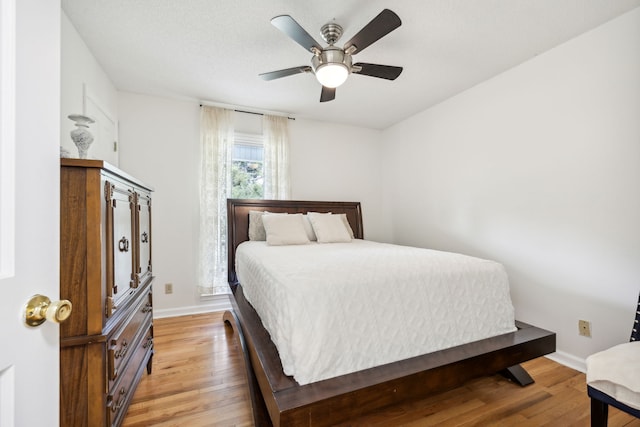 bedroom with ceiling fan and light hardwood / wood-style floors