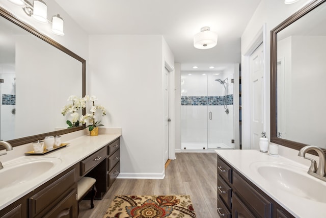 bathroom with walk in shower, vanity, and hardwood / wood-style flooring