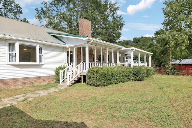 exterior space featuring ceiling fan and a lawn