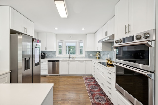 kitchen featuring white cabinets, stainless steel appliances, light wood-type flooring, and sink