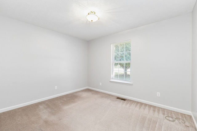 carpeted spare room with a textured ceiling