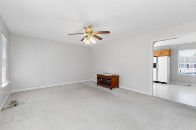 carpeted spare room featuring ceiling fan