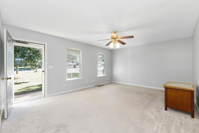 carpeted spare room with a healthy amount of sunlight and ceiling fan