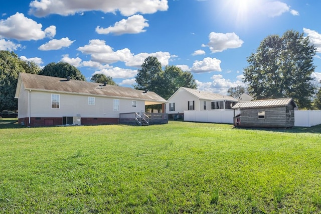 rear view of property with central AC, a shed, and a lawn