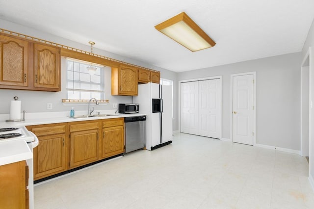 kitchen with appliances with stainless steel finishes, decorative light fixtures, and sink