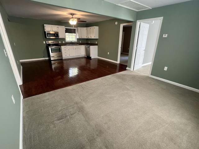 1518 Matlock Dr, Chapmansboro, TN 37035 - kitchen with appliances with stainless steel finishes, dark carpet, white cabinets, baseboards, and dark countertops