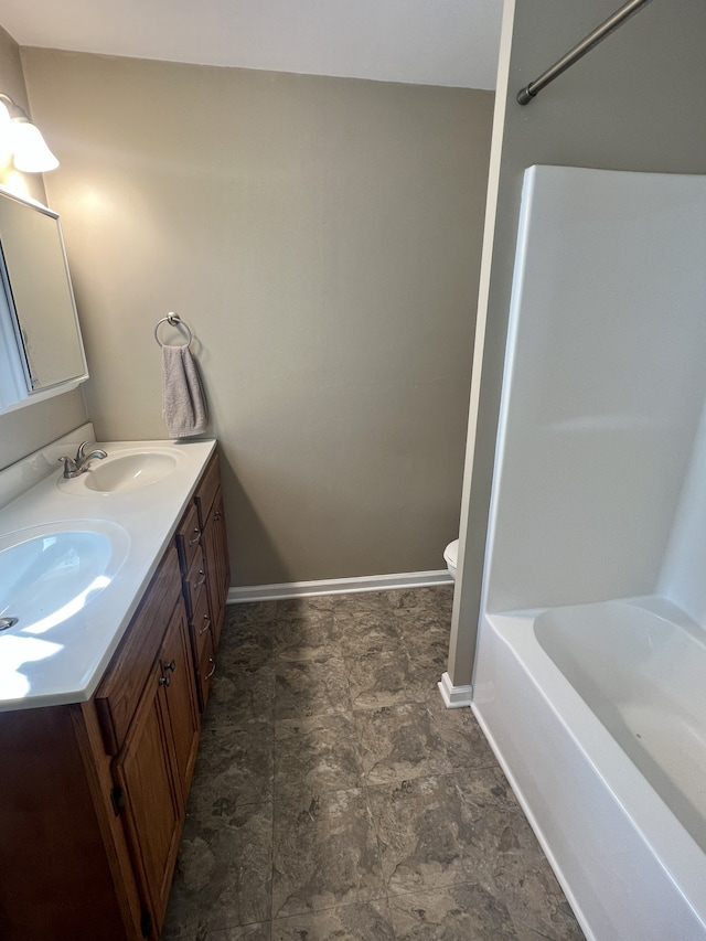 bathroom with a bathtub, vanity, and toilet