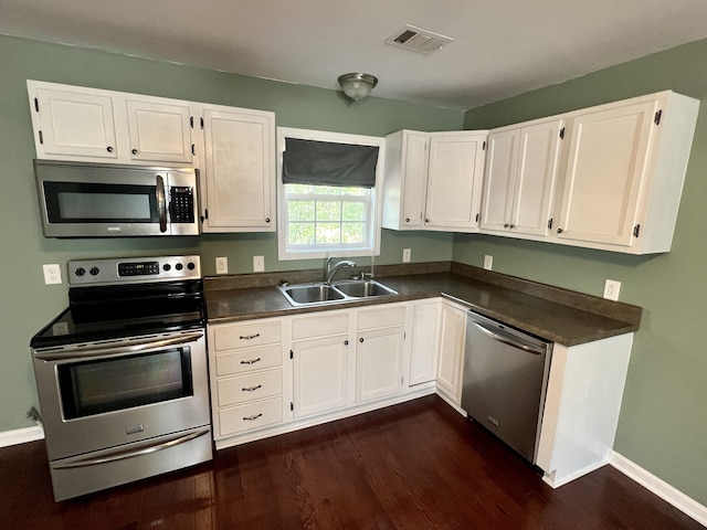 kitchen with white cabinets, stainless steel appliances, dark hardwood / wood-style floors, and sink