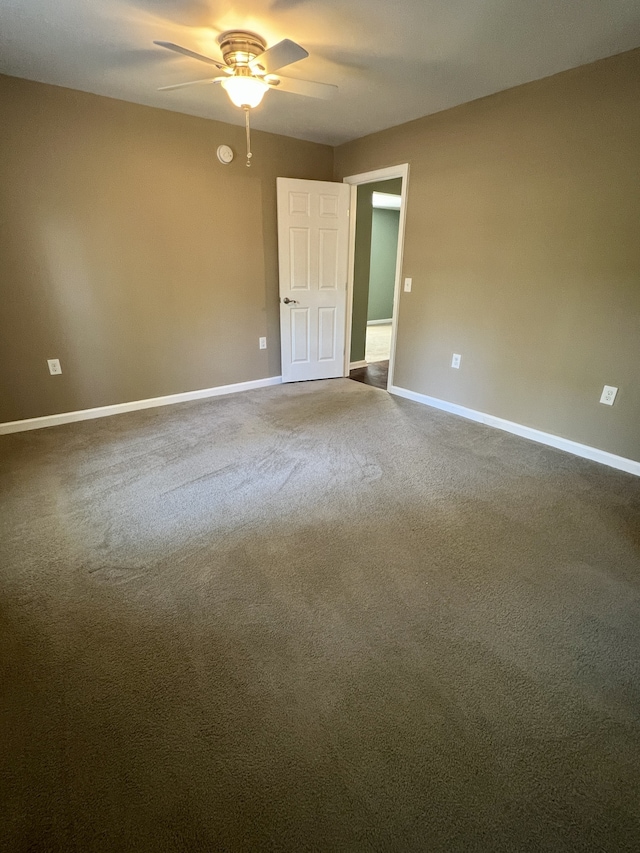 carpeted spare room featuring ceiling fan