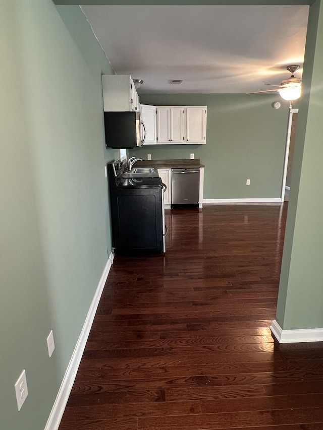 1518 Matlock Dr, Chapmansboro, TN 37035 - kitchen featuring stainless steel appliances, dark wood-style flooring, white cabinetry, baseboards, and ceiling fan