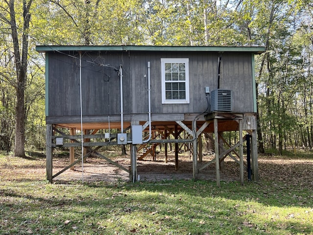 view of outbuilding featuring cooling unit and a lawn