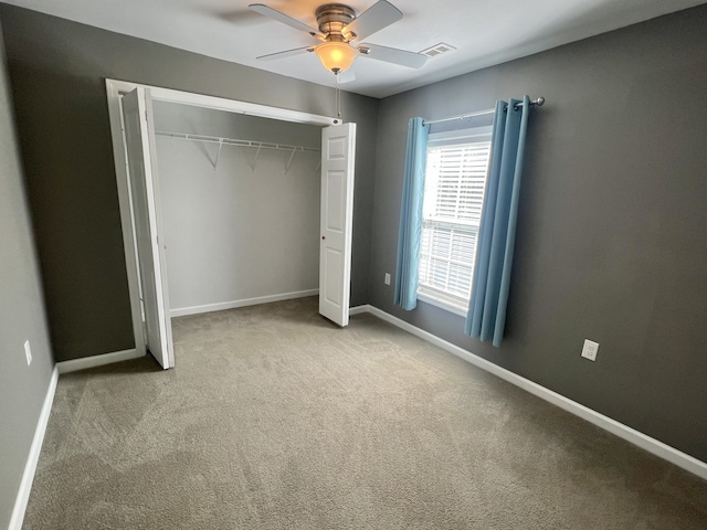 unfurnished bedroom featuring light carpet, ceiling fan, and a closet