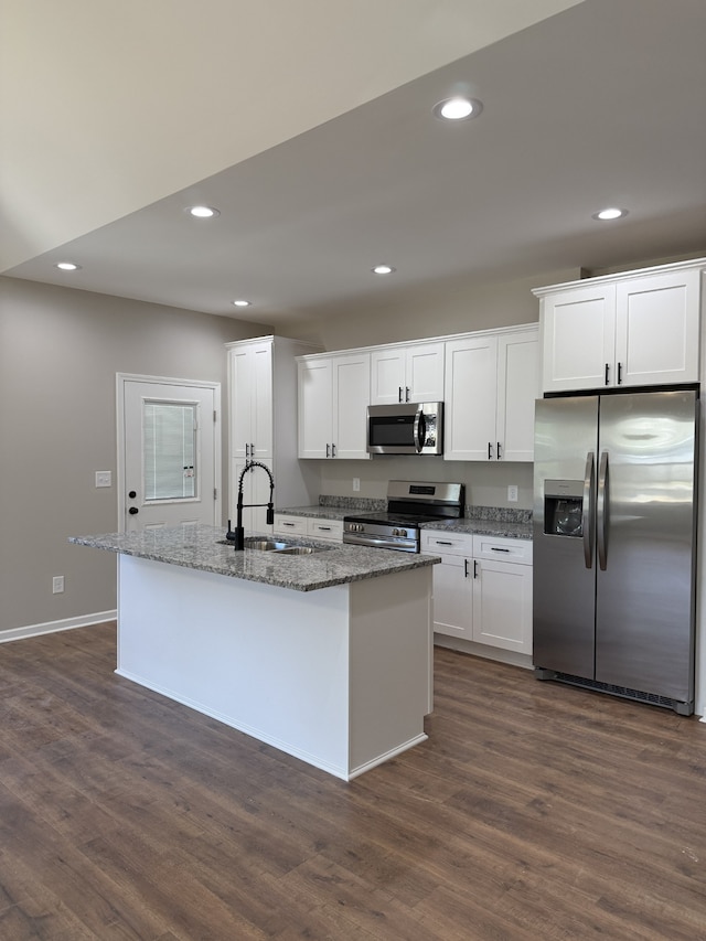 kitchen with a kitchen island with sink, appliances with stainless steel finishes, sink, and white cabinetry