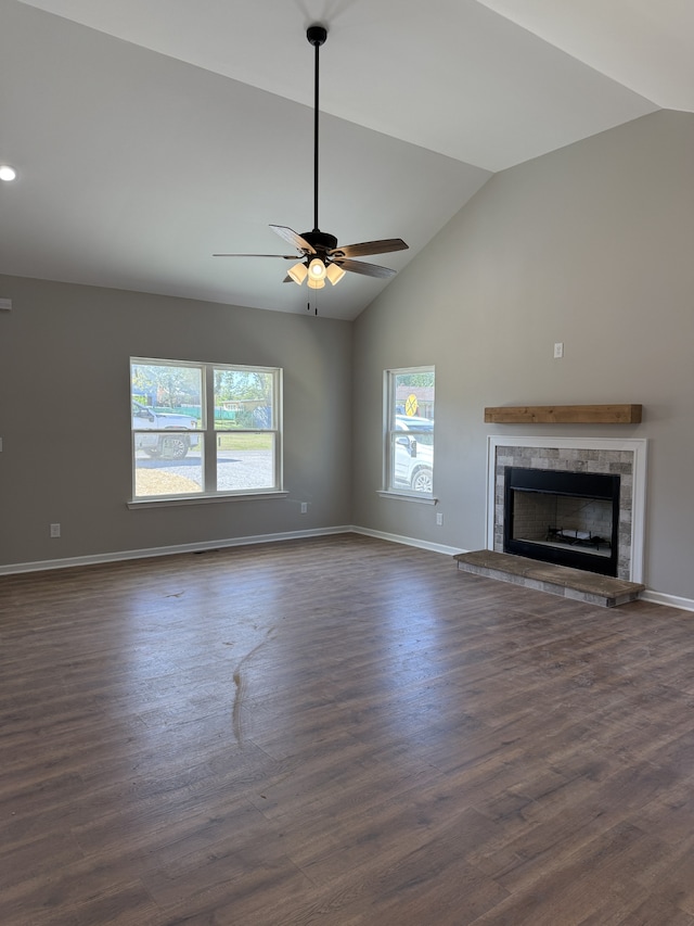 unfurnished living room featuring a healthy amount of sunlight, vaulted ceiling, and dark hardwood / wood-style floors