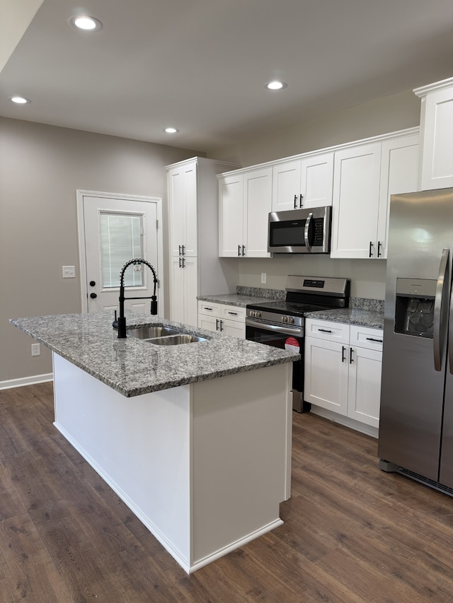 kitchen featuring light stone counters, an island with sink, appliances with stainless steel finishes, and sink