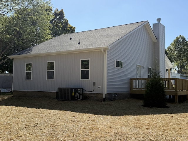 rear view of property with central AC unit and a wooden deck