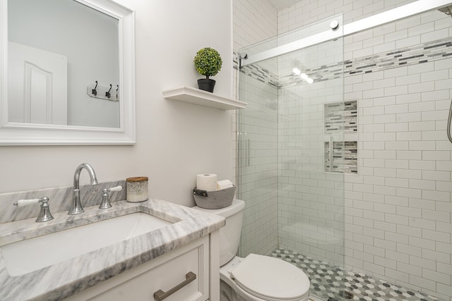 bathroom featuring vanity, walk in shower, and toilet