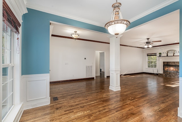 unfurnished living room with ceiling fan, ornate columns, crown molding, a high end fireplace, and dark hardwood / wood-style floors