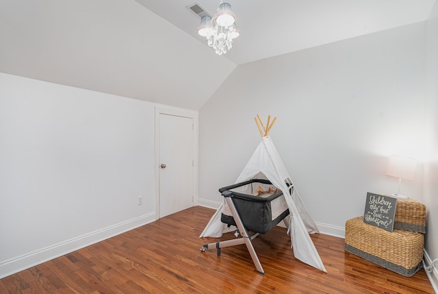 rec room with a notable chandelier, lofted ceiling, and hardwood / wood-style floors