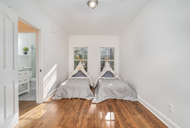 bedroom with wood-type flooring and ensuite bathroom