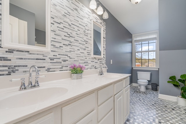 bathroom featuring tile patterned floors, vanity, toilet, and tasteful backsplash