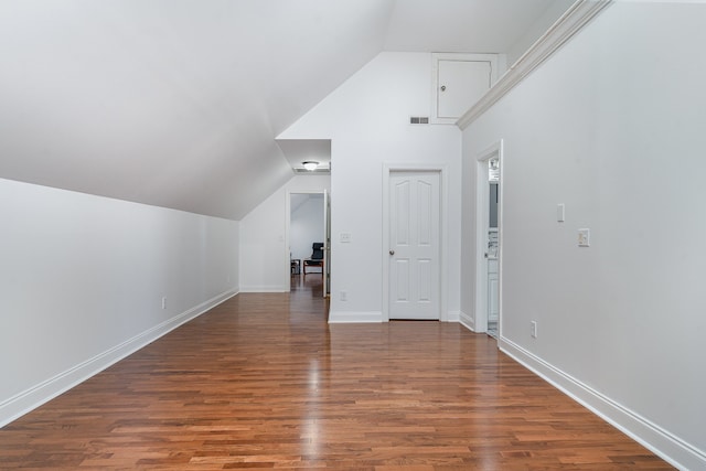 bonus room featuring dark wood-type flooring and vaulted ceiling