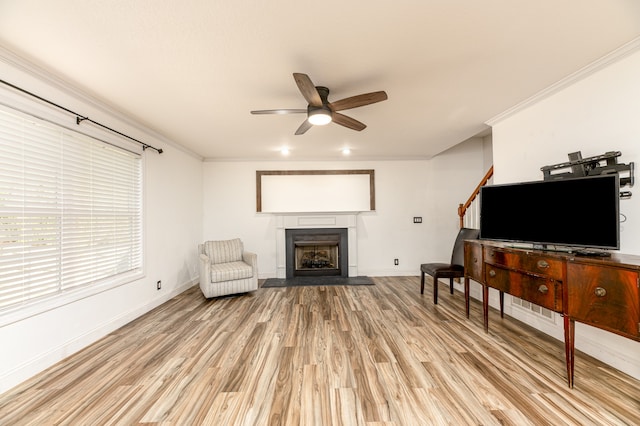 living area with crown molding, light wood-type flooring, and ceiling fan