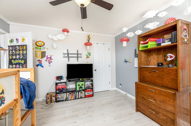 recreation room with crown molding, light hardwood / wood-style floors, and ceiling fan