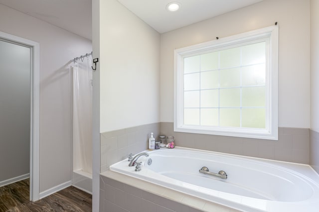 bathroom featuring shower with separate bathtub and hardwood / wood-style floors