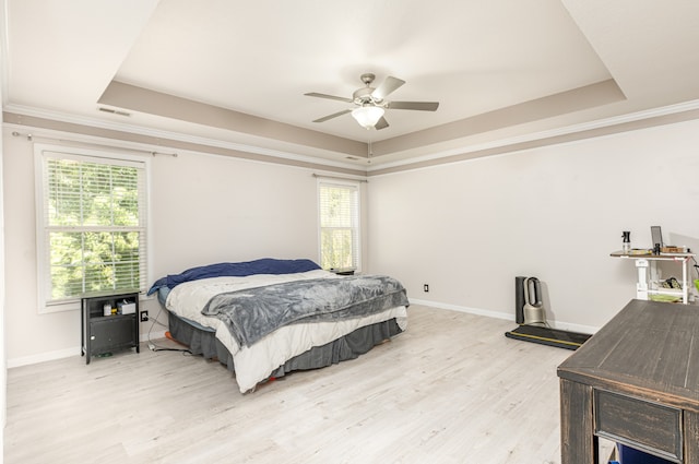 bedroom featuring hardwood / wood-style floors, ceiling fan, crown molding, and a raised ceiling