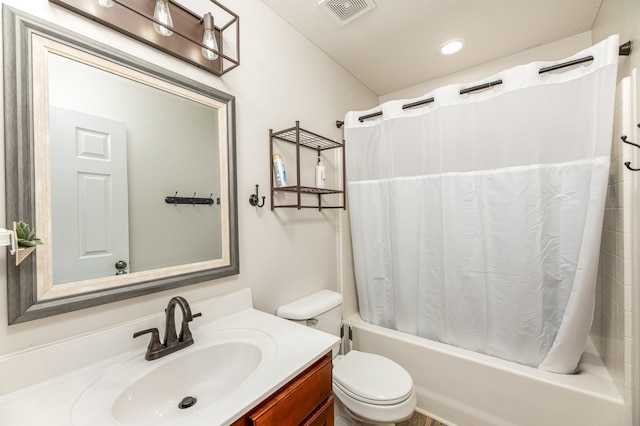 full bathroom with toilet, a textured ceiling, vanity, and shower / tub combo